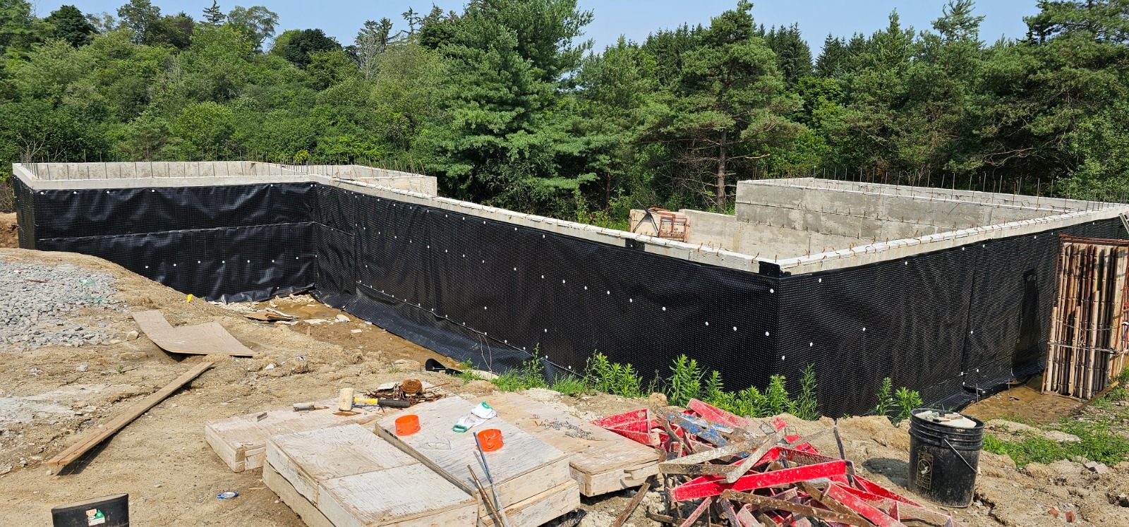 Concrete-block foundation walls with exterior waterproofing membrane during custom home construction