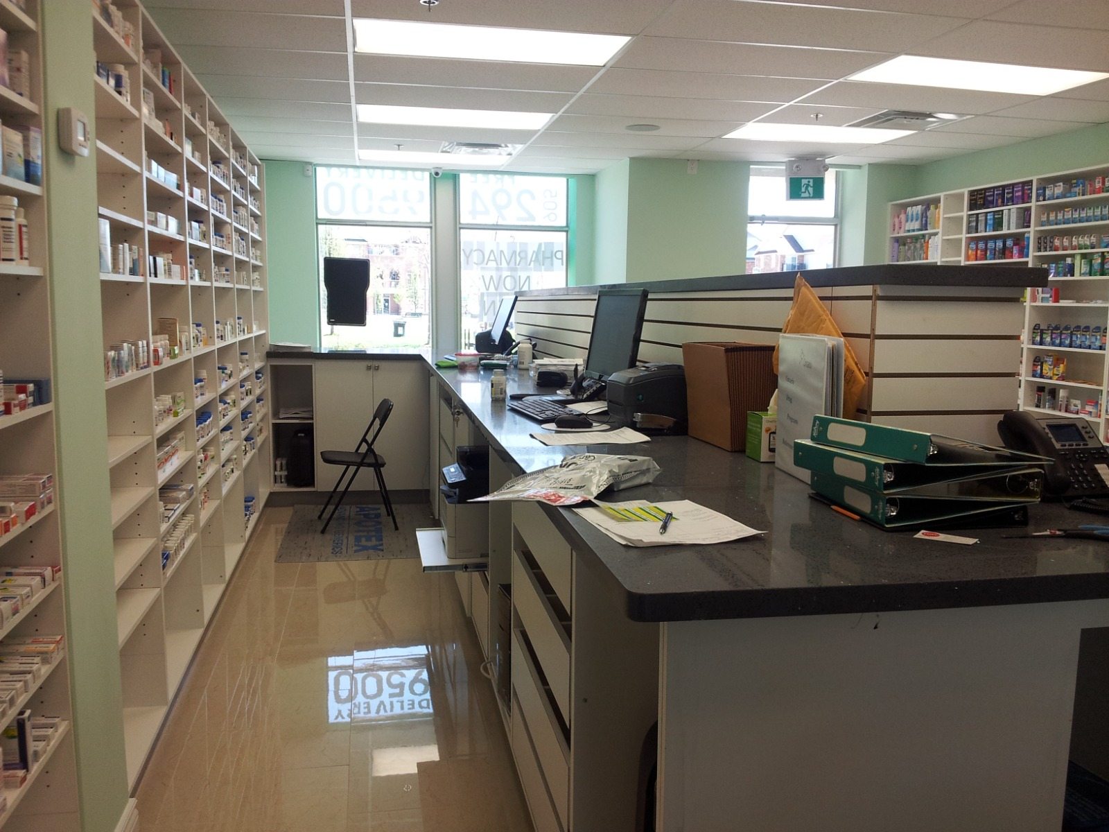 Completed pharmacy dispensary with work counters, storage cabinetry, and overhead panel lighting