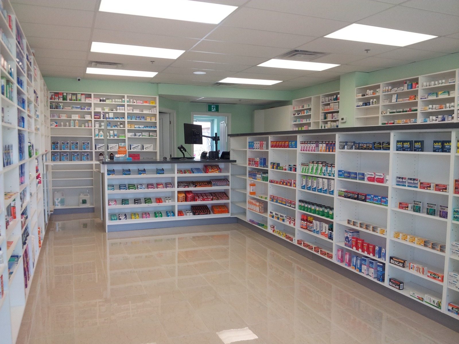 Completed pharmacy retail floor with product shelving, service counters, and polished flooring