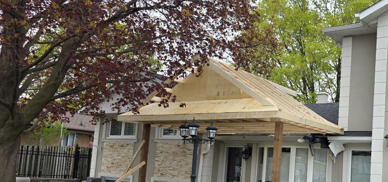 Covered porch roof framing with rafters extending from the new front gable toward the house