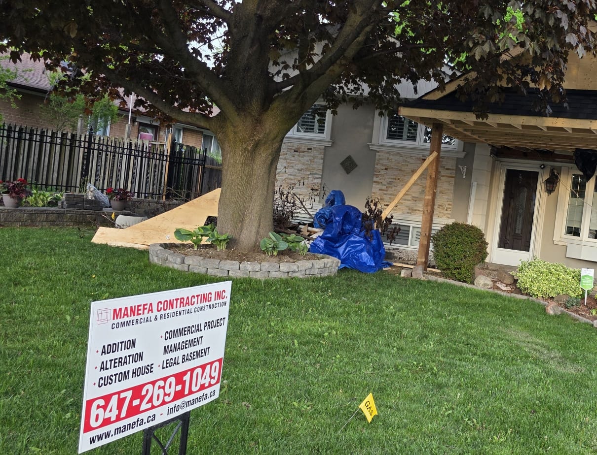 Covered porch addition during roofing with asphalt shingles above the exposed underside framing