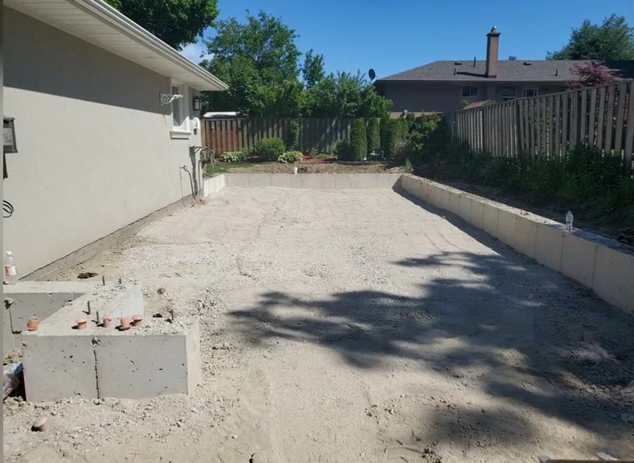 Excavated and graded footprint prepared beside the home for the garage addition
