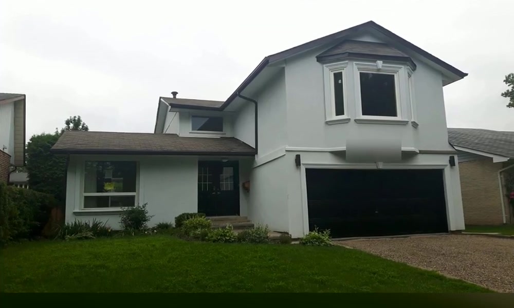 Completed upper-level home addition above the garage with a projecting front window and white exterior