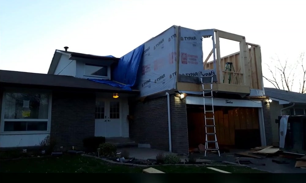 Wood framing and sheathing in progress above the existing garage