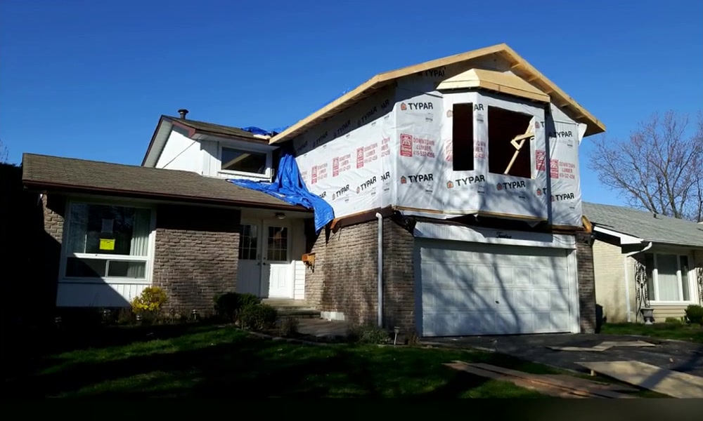 Upper-level home addition enclosed with roof framing, sheathing, and weather barrier
